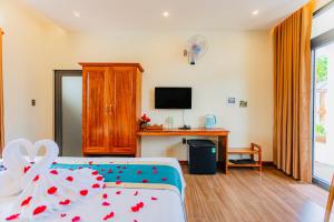 a hotel room with a bed and a tv at Palm Bay Resort Phu Quoc in Phú Quốc