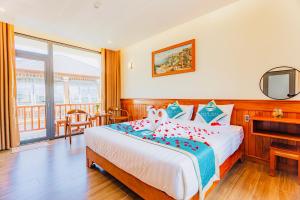 a bedroom with a large bed with red and blue pillows at Palm Bay Resort Phu Quoc in Phú Quốc