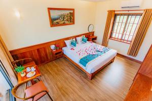 a bedroom with a bed and a table and a window at Palm Bay Resort Phu Quoc in Phú Quốc