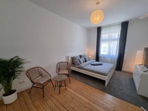 ein Wohnzimmer mit einem Sofa und 2 Stühlen in der Unterkunft Süße Marie 3 in Karlsruhe