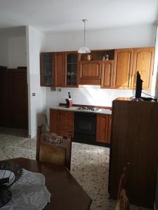 eine Küche mit Holzschränken und einem Herd mit Backofen in der Unterkunft Casa Raffaello in Castiglione dʼOrcia