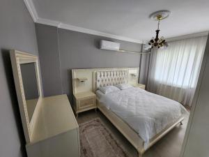 BostancıにあるDeniz manzaralı klimalı daireのベッドルーム(白いベッド1台、鏡付)