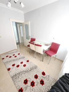 a living room with a table and red chairs at Deniz manzaralı klimalı daire in Bostancı