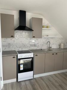 a kitchen with a stove and a sink at Grianan view loft apartment in Tieveborne