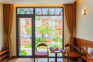 a dining room with a table and a large window at Palm Bay Resort Phu Quoc in Phú Quốc