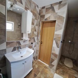 een badkamer met een wastafel en een spiegel en een douche bij Stanovcic Apartments in Herceg-Novi
