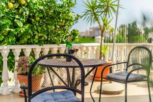 a table and chairs on a balcony with a bottle of wine at Lemon Tree Villa in Paralimni +43 photos