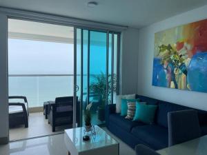 sala de estar con sofá azul y mesa en Apartamento 3404 Palmetto Beach Frente a la playa, en Cartagena de Indias
