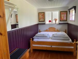 a bedroom with a bed with purple walls at Rustic Haven Bed and Breakfast -Entire Private Apartment 2km from Klarälvsbanan and Swimming area in Munkfors