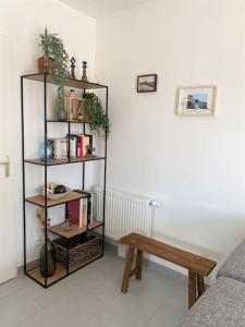 a living room with a book shelf and a bench at Appt confort avec terrasse au calme à Fouras! in Fouras