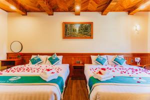a bedroom with two beds with flowers on them at Palm Bay Resort Phu Quoc in Phú Quốc +33 photos