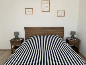 a bedroom with a black and white striped bed and two tables at Appt confort avec terrasse au calme à Fouras! in Fouras