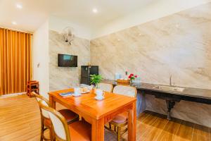 a kitchen and dining room with a wooden table and chairs at Palm Bay Resort Phu Quoc in Phú Quốc
