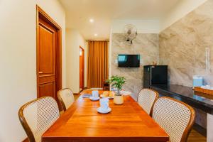 a dining room with a wooden table and chairs at Palm Bay Resort Phu Quoc in Phú Quốc