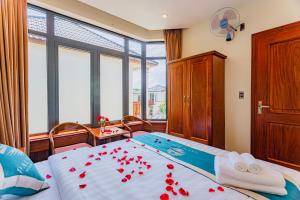 a bedroom with a bed with red roses on it at Palm Bay Resort Phu Quoc in Phú Quốc