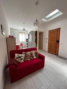 sala de estar con sofá rojo y cocina en Grazioso bilocale Da Zia Bruna, en Vallecrosia