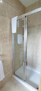 a shower with a glass door in a bathroom at Golf'Inn Enniscrone in Enniscrone