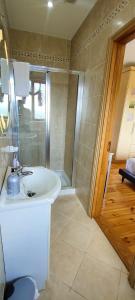 a bathroom with a white sink and a shower at Golf'Inn Enniscrone in Enniscrone