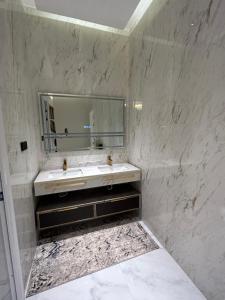 Baño blanco con lavabo y espejo en شقة فاخرة غرفة وصالة بالعارض ٢ en Riad