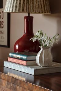 una pila di libri e un vaso con fiori su un tavolo di The Kirkstyle Inn & Sportsman Rest a Brampton