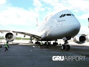 a group of people standing around an airplane on a runway at suite Perto do aeroporto de guarulhosAv Jovita 401 in Guarulhos