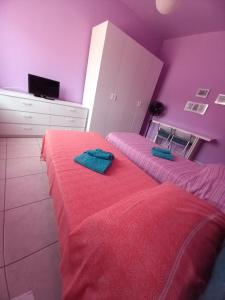 two beds in a room with purple walls at Affittacamere Appartamento colorato in Ferrara +50 photos