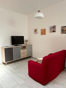 sala de estar con sofá rojo y TV en Grazioso bilocale Da Zia Bruna, en Vallecrosia