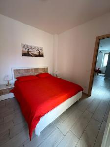 1 dormitorio con 1 cama roja en una habitación en Grazioso bilocale Da Zia Bruna, en Vallecrosia