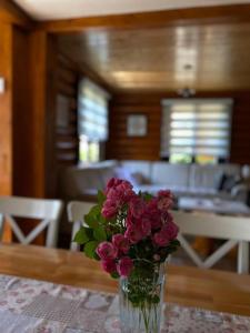 a vase filled with pink flowers sitting on a table at Ruralna kuća za odmor Marta in Otočac