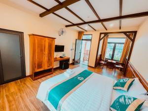 a bedroom with a large bed and a desk at Palm Bay Resort Phu Quoc in Phú Quốc