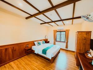 a bedroom with a bed in a room with wooden floors at Palm Bay Resort Phu Quoc in Phú Quốc