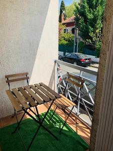 een bank en stoelen op een balkon met een auto bij Appartement Rangeuil Toulouse in Toulouse