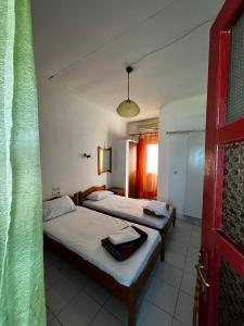 a room with two beds and a red door at Selena Rooms in Agia Galini