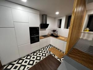 cocina con armarios blancos y suelo a cuadros en Porto Apartamento relaxante na cidade en Oporto