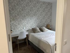 1 dormitorio con cama, escritorio y pared en Porto Apartamento relaxante na cidade en Oporto