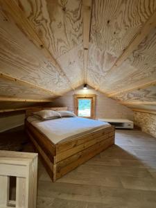 a large bed in a room with a wooden ceiling at Tiny-House Chalet Al måjhinete in Lodève