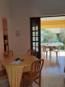 a dining room with a table and chairs and a window at RESIDENCE MON REFUGE in Grande Anse