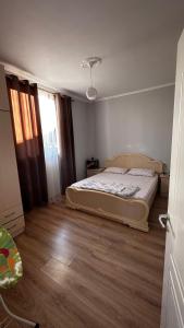 a bedroom with a bed and a wooden floor at Priam Garden in Durrës