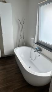 a white bath tub in a bathroom with a window at Au petit alveo in Sprimont
