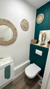 uma casa de banho com um WC branco e um espelho. em Au petit alveo em Sprimont