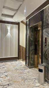 a lobby with a glass door and a marble floor at فندق pulse للأجنحة الفندقية in Khamis Mushayt