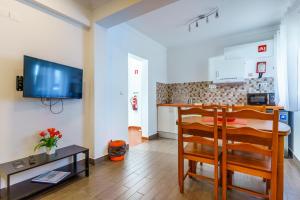 a kitchen and a dining room with a table and a television at Mar- Milfontes Rentals in Vila Nova de Milfontes