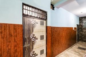 drewniane drzwi z krzyżem w pokoju w obiekcie OYO Flagship 84929 Omax Guest House w mieście Faridabad