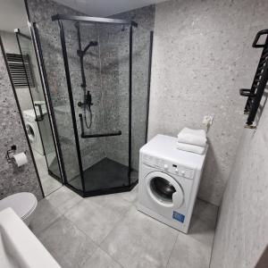 a bathroom with a shower and a washing machine at ewja 4 in Sulęcin +12 photos