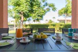 uma mesa com uma taça de fruta e sumo de laranja em Villa Seaside - Beach Retreat with jacuzzi em Siracusa
