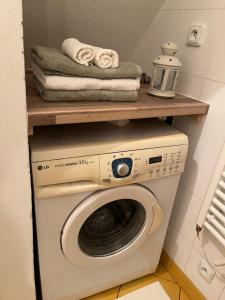 a laundry room with a washing machine and a wooden shelf at Apartmán Z.E.M. 