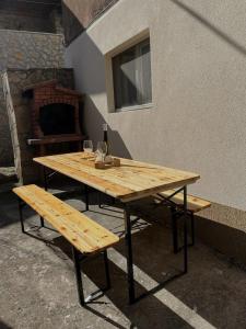 a wooden table with a bench and a bottle of wine at Secret Place Apartment in Stari Grad