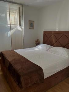 Schlafzimmer mit einem großen Bett mit einem Kopfteil aus Holz in der Unterkunft Secret Place Apartment in Stari Grad
