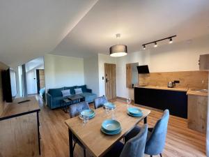 a dining room and living room with a table and chairs at Apartamenty MarSyl in Jastrzębia Góra