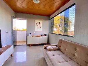 a living room with a couch and a large window at 3 Quartos Com Vista Espetacular in Brasilia
